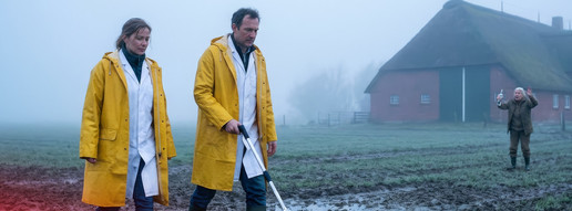 PTA-Vertretung: Kilometernachweis per Rolltacho KI-Montage: Zwei Apothekenmitarbeitende laufen über einen Acker in Norddeutschland.