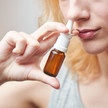 Nasenspray: Wenn Imidazoline zur Sucht werden Foto: Eine Frau sprüht sich Nasenspray in die Nase