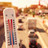 Hitze: Hunderte zusätzliche Todesfälle Symbolbild: Das Foto zeigt im Vordergrund ein Thermometer. Im Hintergrund ist eine sonnenbeschienene, mehrspurige und stark befahrene Straße zu sehen.
