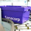 Dividende: Sanacorp hebt Umsatzschwelle an Eine blaue Sanacorp-Wanne fährt über das Förderband. Mehr dazu im Artikel.