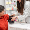 pDL: Schluss mit der Scheu am HV-Tisch Foto: Eine Person in weißem Kittel legt in der Apotheke einer weiteren Person eine Oberarmmanschette an