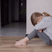 Depression bei Kindern: Welche Medikamente helfen Foto: Ein Kind sitzt auf dem Boden und vergräbt sein Gesicht