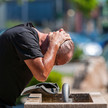 Hitze stört Wirkung von Psychopharmaka Mann kühlt sich an einem Trinkbrunnen