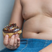 Adipositas: Übergewicht bei Kindern fördert Krebs dickes Kind isst Donut