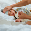 Neue Leitlinie: Fieber nicht vorschnell senken Foto: Ein Kleinkind liegt mit Fieber im Bett
