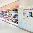 dm-Apotheke schickt erste Testpäckchen dm-Regale und die Abholstation mit Schließfächern im Markt