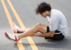 Junger Mann mit Wadenkrampf auf Strasse 1
