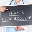 Sparreform: Viele Praxen bleiben geschlossen! Symbolbild: Person im kittel hät Schild mit der Aufschrift „Praxis geschlossen“